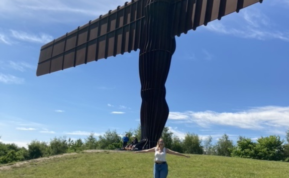 Olivia stood in front of the Angel of the North with her arms spread out wide